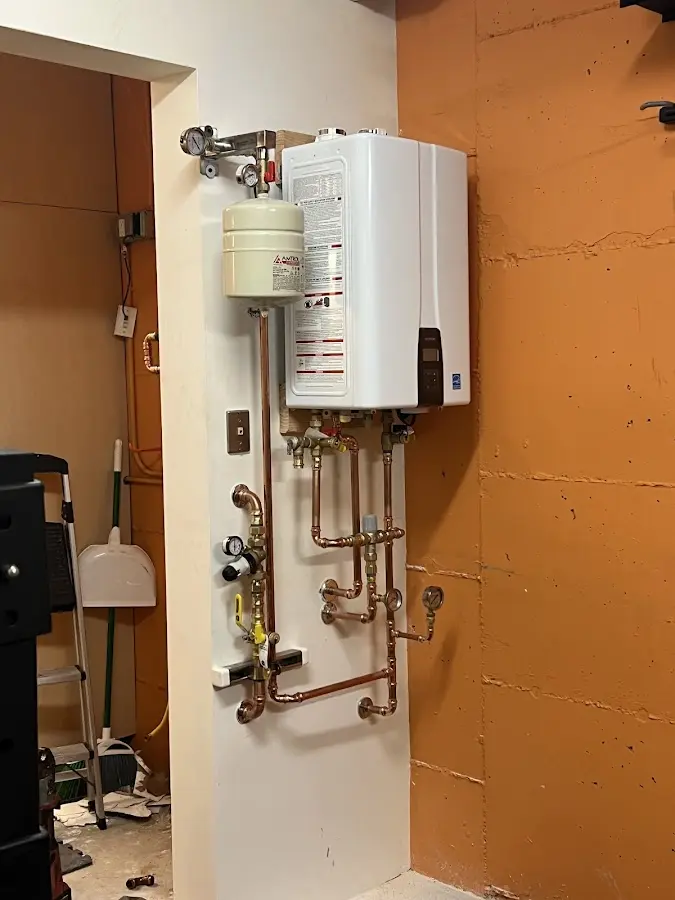 Plumbing technician inspecting water heater connections in Cold Springs